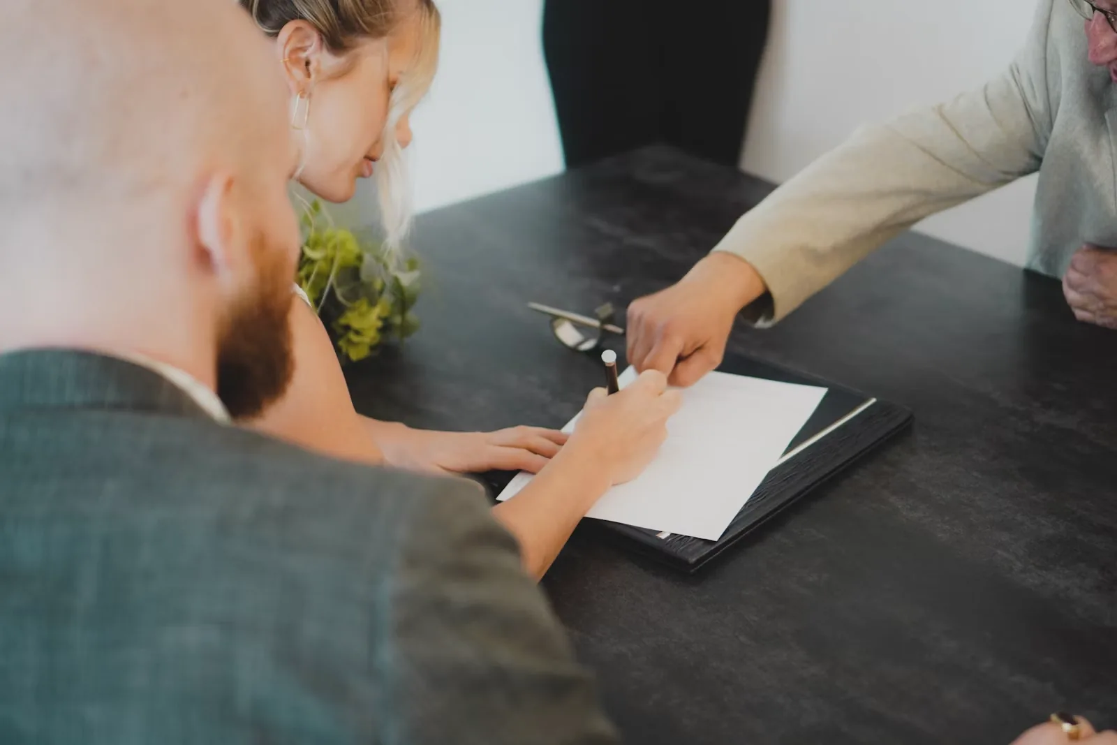 Couple reviewing and signing documents together at a desk