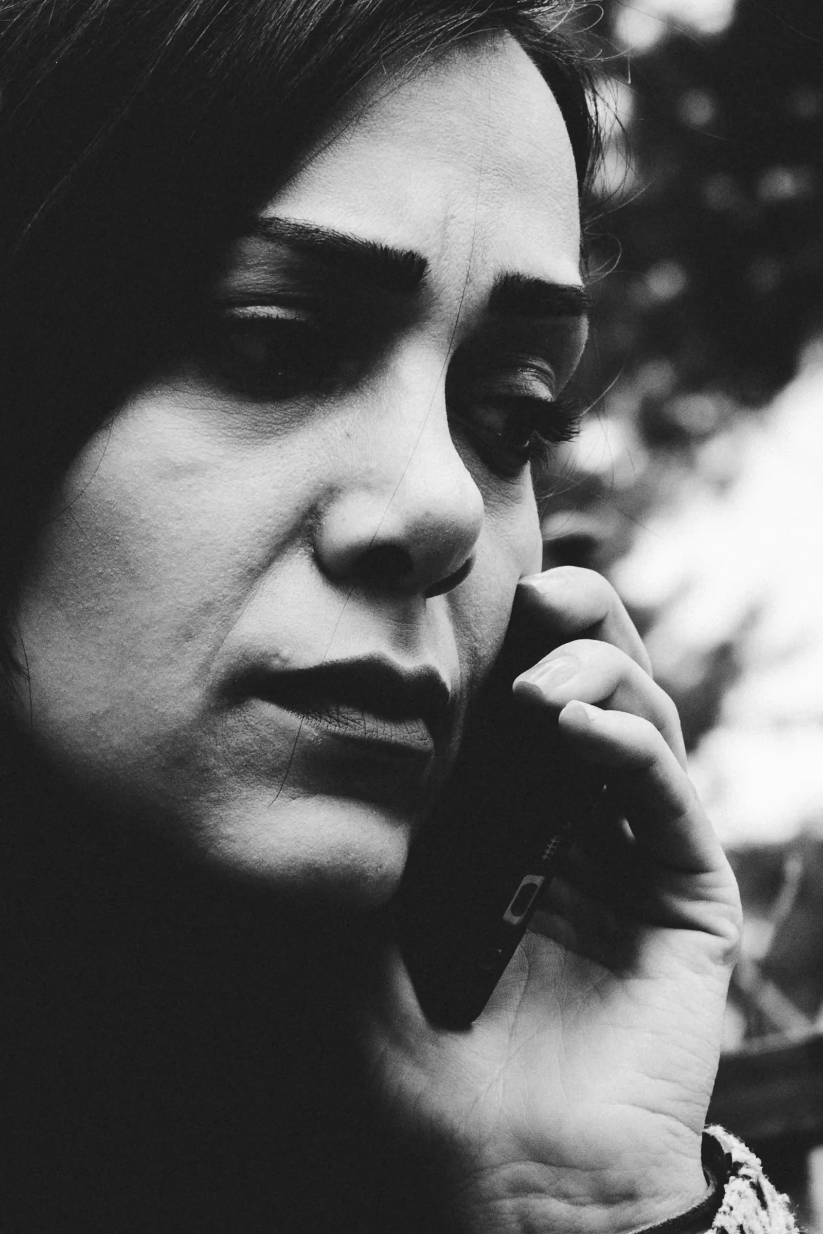 Woman talking on a cell phone with a concerned expression